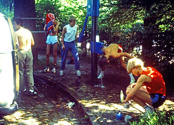 Waschen an einer Wasserpumpe in einem Park